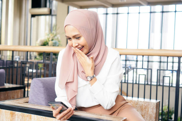 istock Happy Muslim female using smartphone in cafe 1249112802