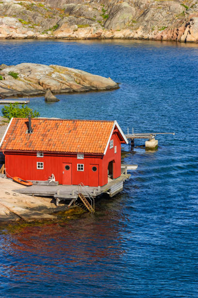 istock Red boathouse on the beach by the sea 1249116563