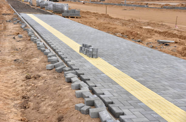 Laying paving slabs at construction site. Process of installing paving bricks in the town pedestrian zone. Screeding the sand for install concrete blocks. Road works for pavement renovation