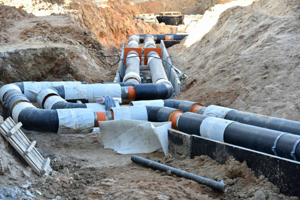 istock Laying heating pipes in a trench at construction site. Install underground storm systems of water main and sanitary sewer. 1249116989