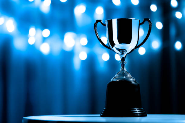 Silver Trophy competition in the dark on the abstract blurred light background with copy space, Blue Tone Silver Trophy competition in the dark on the abstract blurred light background with copy space, Blue Tone championship stock pictures, royalty-free photos & images