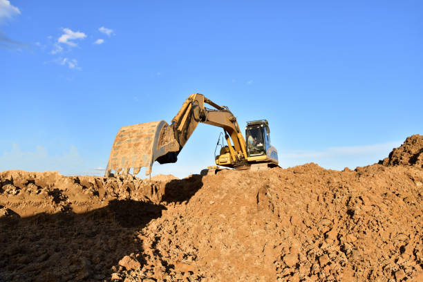 istock Excavator working on earthmoving at open pit mining. Backhoe digs gravel in quarry. 1249117893