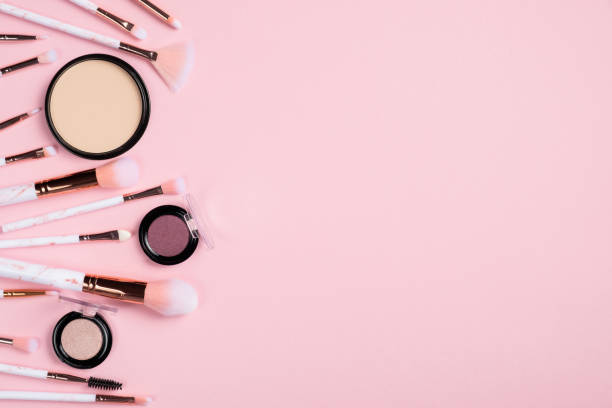 istock Set of different makeup brushes, makeup tools, powder and eye shadow on pink background. Flat lay, top view. Make up store banner design. 1249118743