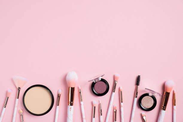 istock Makeup brushes and cosmetics products on pink background. Flat lay, top view. 1249118764