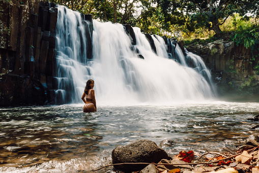 Rochester Falls and woman in bikini. Amazing cascade waterfall in Mauritius