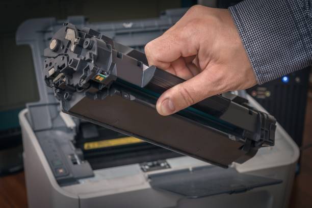 istock Man is replacing black cartridge in a laser printer 1249120805