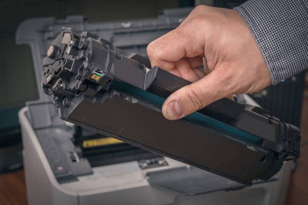 istock Man is replacing black cartridge in a laser printer 1249120821