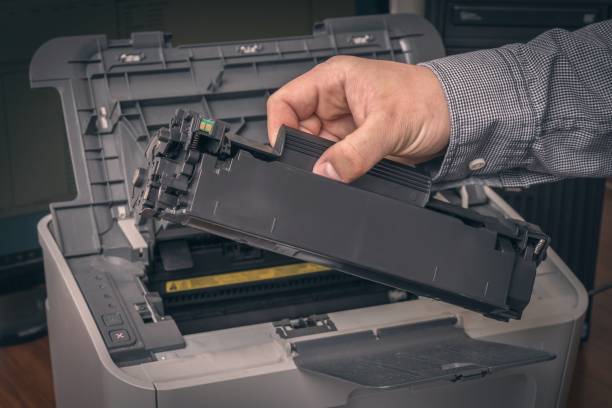 istock Man is replacing black cartridge in a laser printer 1249120848