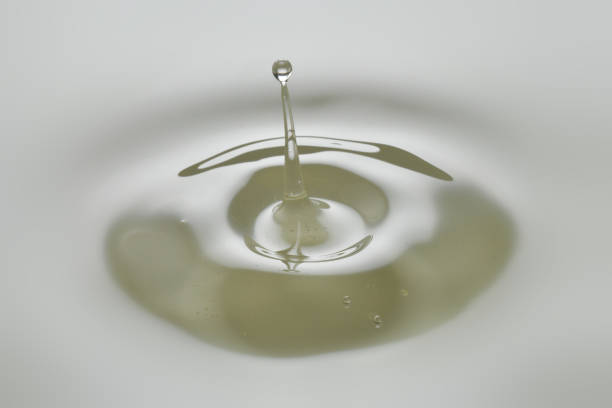 istock Dripping colorless oil on white background. 1249121311