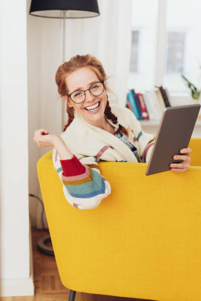 istock Vivacious young redhead woman reading a tablet 1249123542