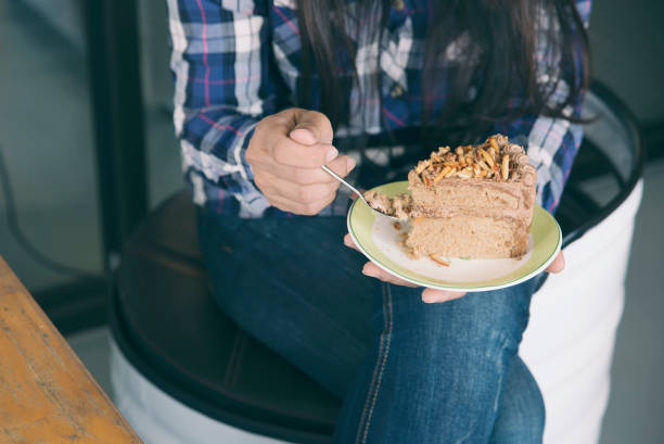 Asian woman eating diet cake.Lifestyle of Happy young female smiled and enjoyed eat dessert at coffee shop.Diet cake concept.