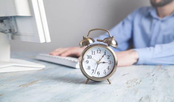 istock Alarm clock on the desk. Businessman working in office 1249141522