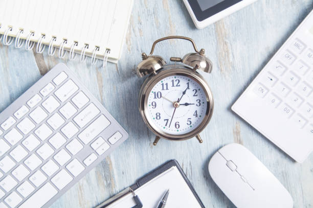 istock Alarm clock with business object on the desk. 1249141528