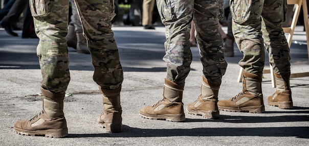 Primer plano de soldados seguidos. Detalle de botas militares y uniformes de camuflaje. photo