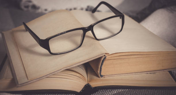 istock Stack of open vintage books with glasses 1249144333