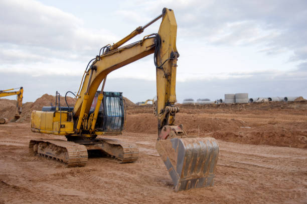 istock Excavator during earthmoving at construction site. Backhoe dig ground for the construction of foundation and laying sewer pipes district heating 1249144430