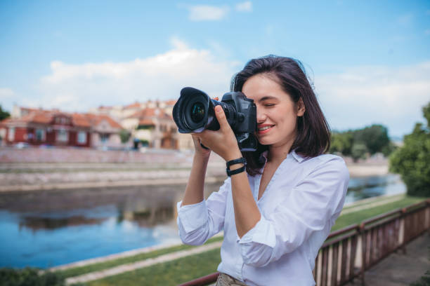 istock Happy woman smiling with a camera in the park 1249144541