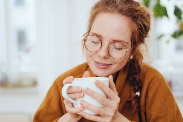 istock Girl in glasses enjoying hot beverage in cup 1249145221