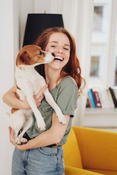 istock Laughing woman holding her pet dog 1249145550