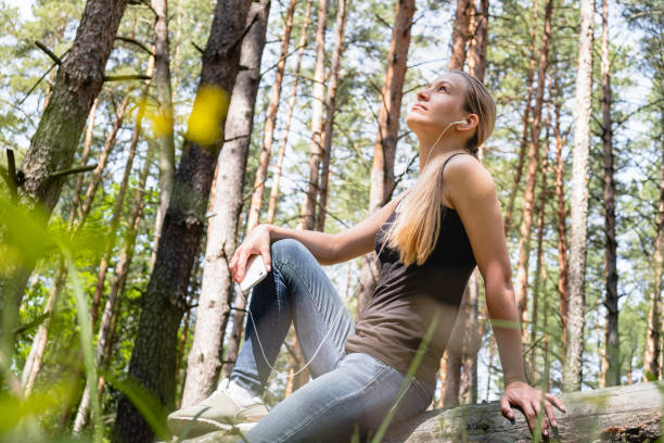 istock a girl in a forest sits leaning against a tree 1249146874