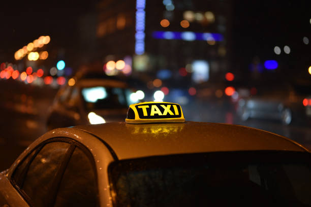Street photography near Grand Central Station, New York City.  This is on a very wet and dark spring night with wet roads creating reflections of two yellow cabs at a cross roads.  Slow shutter speed creates movement blur for intentional camera movement and give a an abstract background.