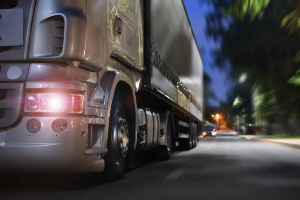 грузовик едет по ночной дороге - gray line horizontal outdoors urban scene стоковые фото и изображения