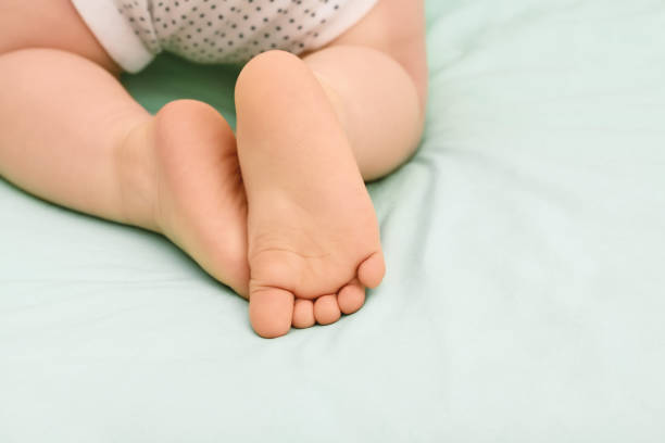 istock Baby feet on green sheet, close up. 1249150107