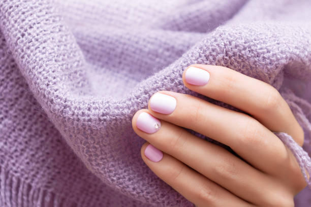 istock Female hand with light purple nail design 1249151925