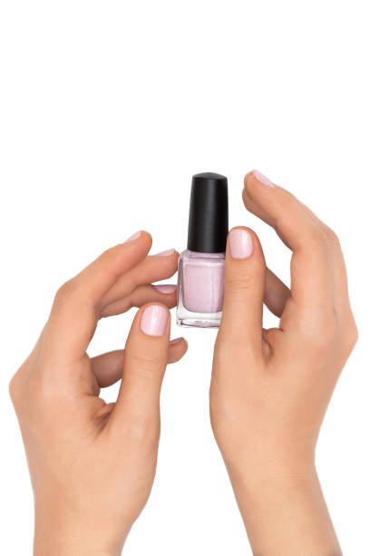 istock Female hands holding nail polish bottle on white background. 1249151965