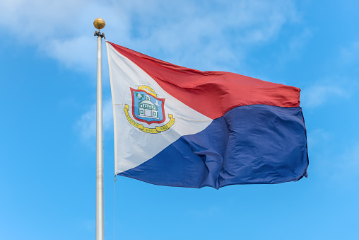 The national flag of Sint Maarten fluttering in the wind, a country within the Kingdom of the Netherlands occupying the southern half of the island of Saint Martin (Dutch part)