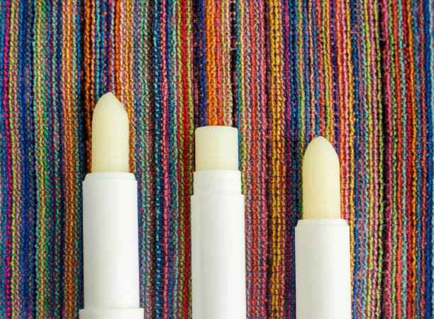 Three lip balms, sunscreen sticks on the colorful beach towel. Summer lip treatment and UV protection. Close up, flat lay, copy space Three lip balms, sunscreen sticks on the colorful beach towel. Summer lip treatment and UV protection. Close up, flat lay, copy space vitamin b 3 stock pictures, royalty-free photos & images