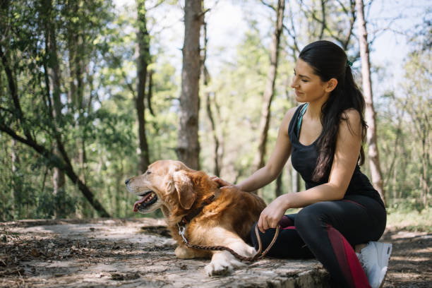 istock Smiling girl resting in forest with her dog 1249156053
