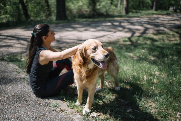 istock Female athlete sitting on the grass with dog 1249156644