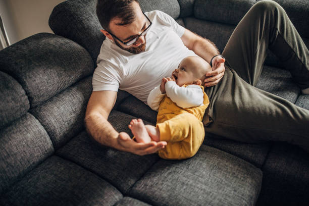 istock Father and baby son relaxing on sofa together 1249156854