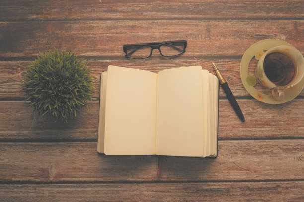 istock high angle view of open diary, tea and eyeglass on wooden table 1249157002