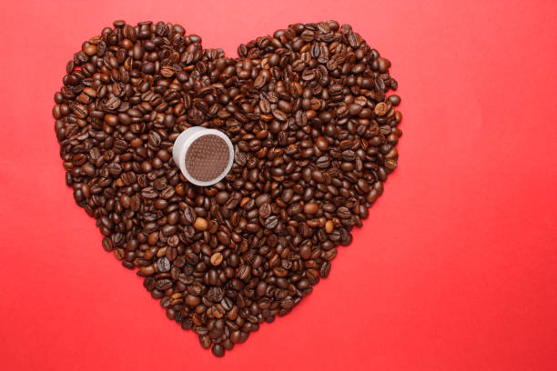 istock Heart made from many roasted coffee beans on a red background 1249157644
