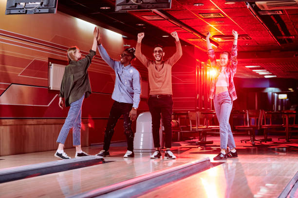 istock Young excited intercultural couples expressing gladness by bowling track 1249160304