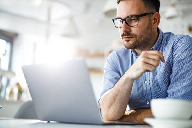 istock Serious businessman reading an e-mail on laptop at home. 1249160388