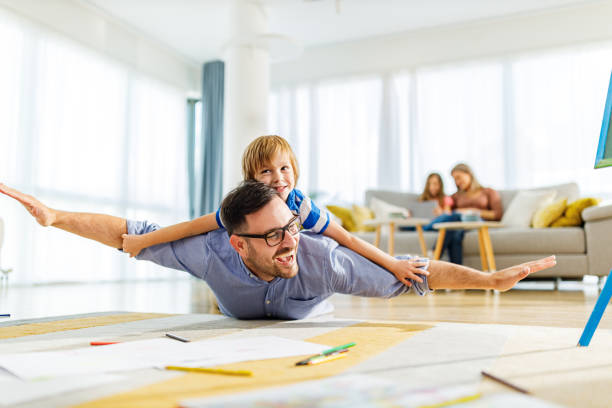 istock Playful father and son having fun on floor at home. 1249160447