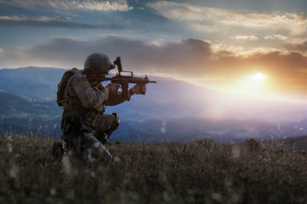 sagoma di un soldato inginocchiato al tramonto - counter terrorism foto e immagini stock