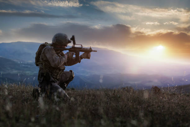 силуэт стоящего на коленях солдата на закате - counter terrorism стоковые фото и изображения