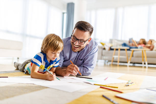 istock Happy father and son enjoying while coloring on floor at home. 1249162536