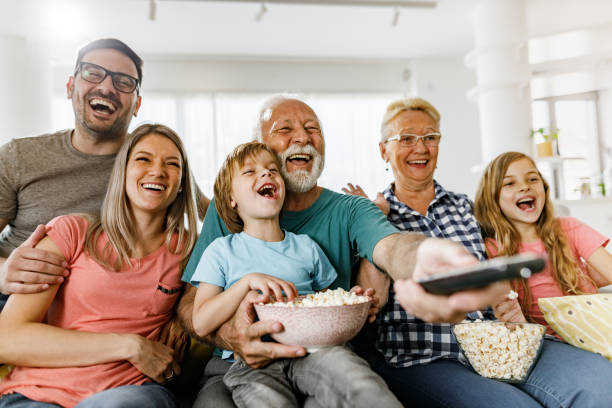 istock Cheerful extended family having fun while watching a movie at home. 1249163144