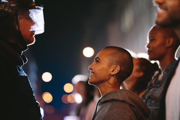 istock Female activist smiling at the policeman during a protest 1249163408