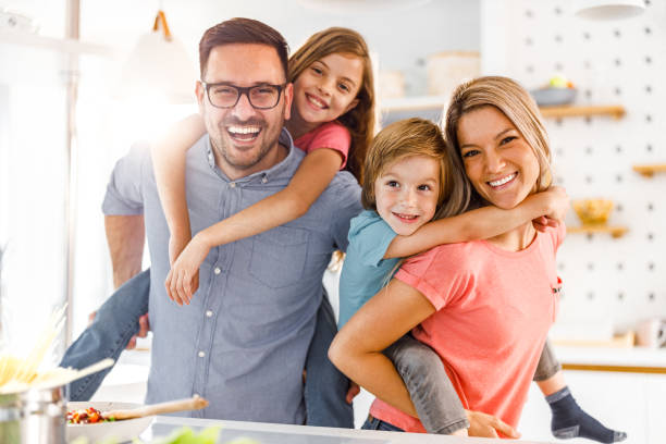 istock Young happy family having fun while piggybacking in the kitchen. 1249163457