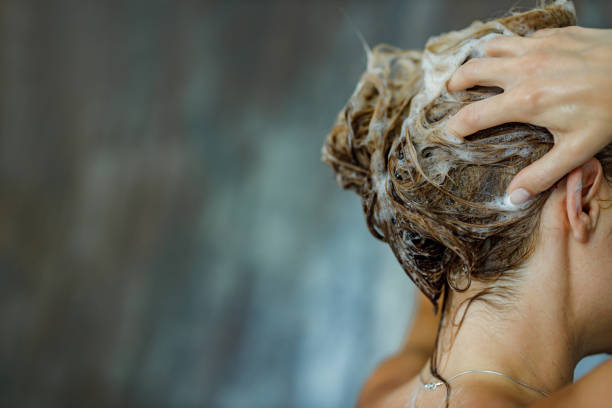 Close up of washing hair with shampoo! Close up of a woman washing her hair with a shampoo in bathroom. Copy space. washing hair stock pictures, royalty-free photos & images