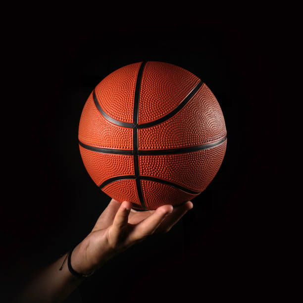 istock Basketball and hand on black background 1249164835