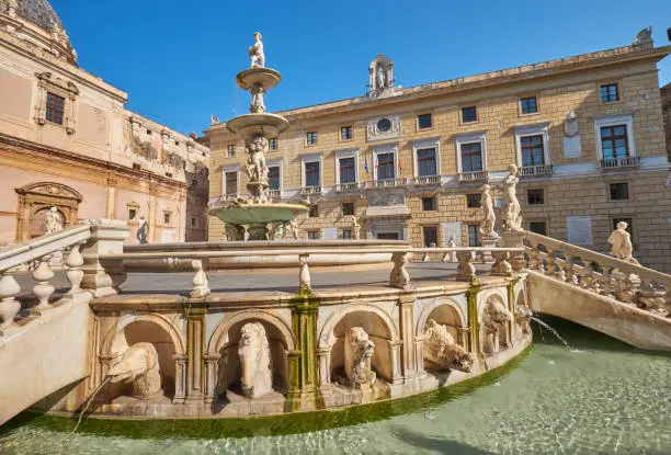 Photo of Fontana Pretoria Palermo decorated with mythological Statues on the square Pretoria Palermo, the town hall of Palermo in the background