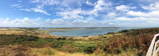 Panorama of Christchurch Harbour from Hengistbury Head, Dorset, England Panoramic scenery view from Hengistbury Head, headland peninsula of the beautiful tranquil natural recreational harbour of Christchurch Harbour, leading to Christchurch seen in the distance hengistbury head photos stock pictures, royalty-free photos & images