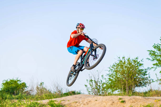 istock Professional cyclist in a bright T-shirt performs a jump. 1249174436